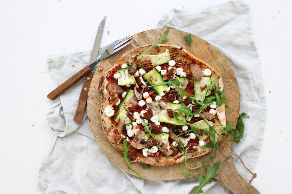 Pizza van Libanees platbrood met geitenkaas, courgette, walnoten en rucola